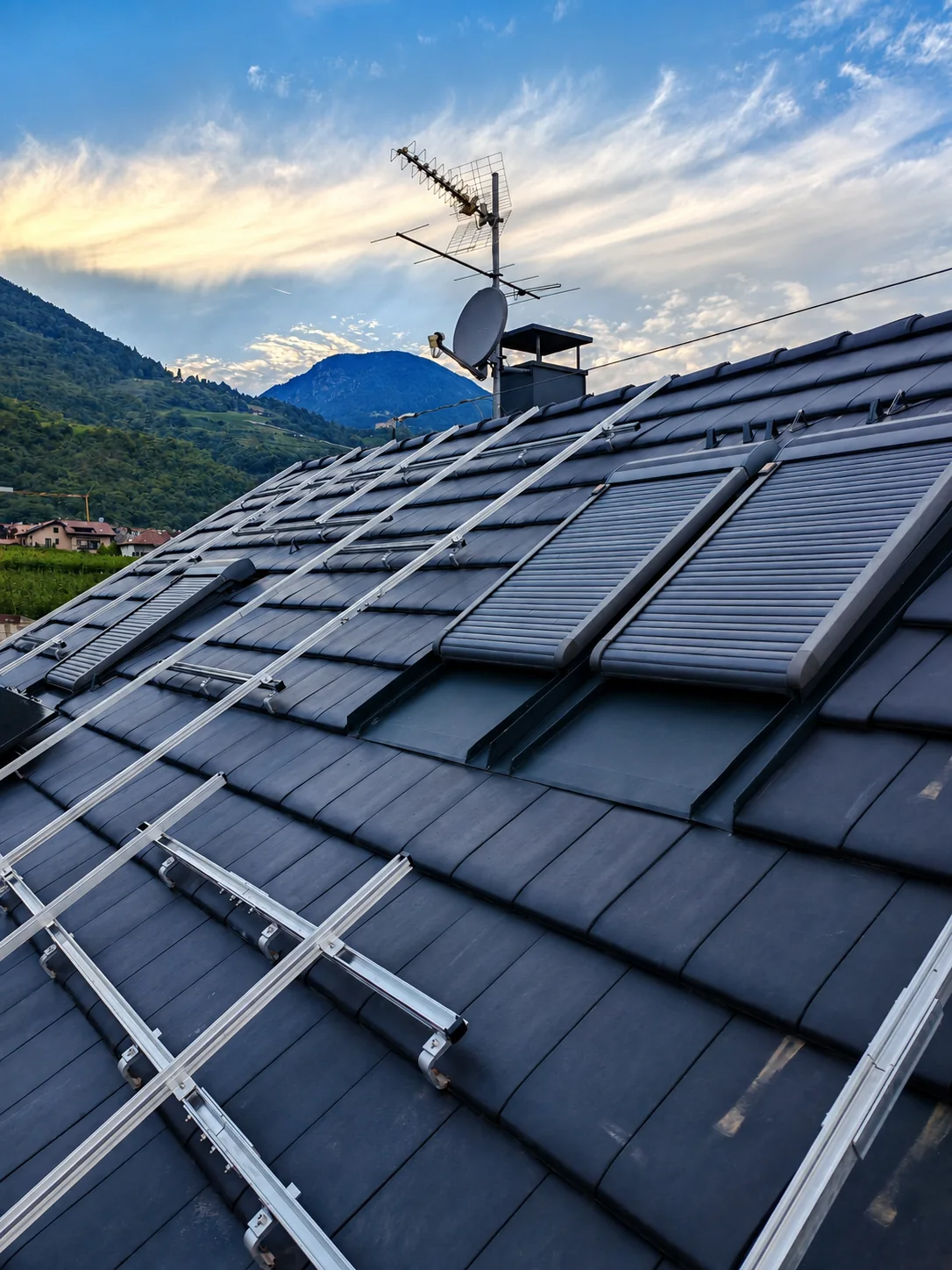 Hochformatige Aufnahme von PV-Montageschienen und Solarthermie auf einem Steildach